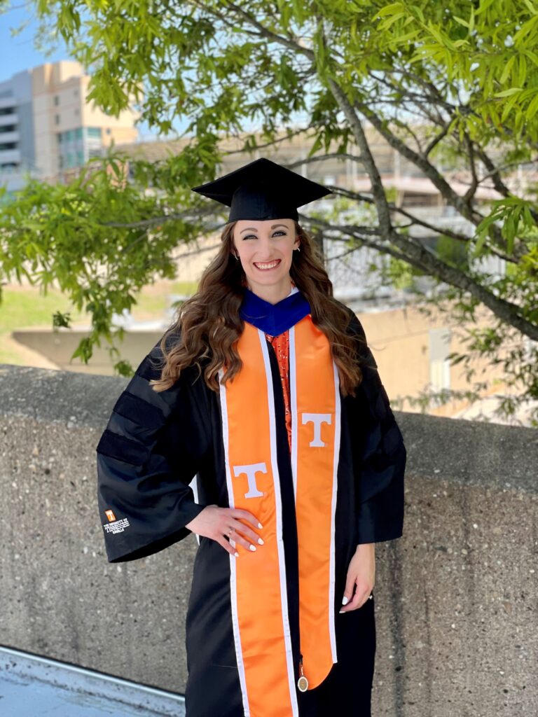 Taylor poses in graduation regalia